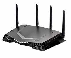 A black wireless router with four antennas